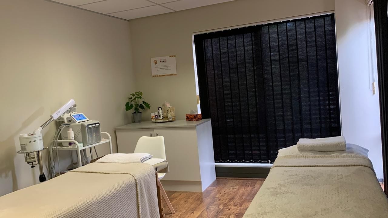 The treatment room at Skincare by Gellie — a made-up treatment bed beside the hydra-dermabrasion machine and a magnifying lamp.